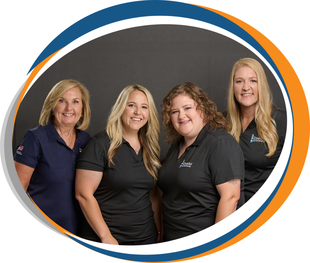 Four Coastal Air Conditioning staff members smiling in company uniforms