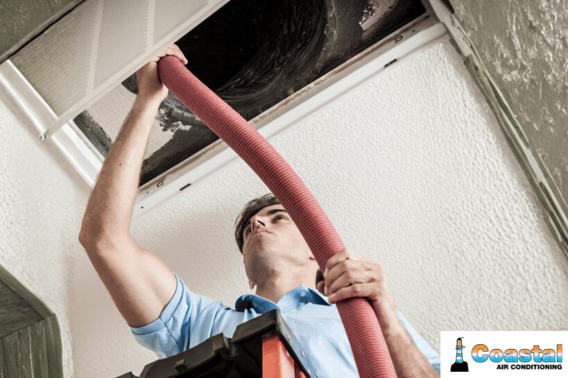 HVAC technician repairing leaky or damaged air ducts on ceiling