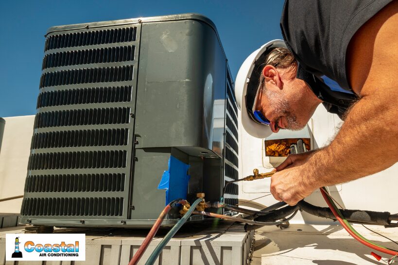 Technician servicing an outdoor HVAC unit under direct sunlight